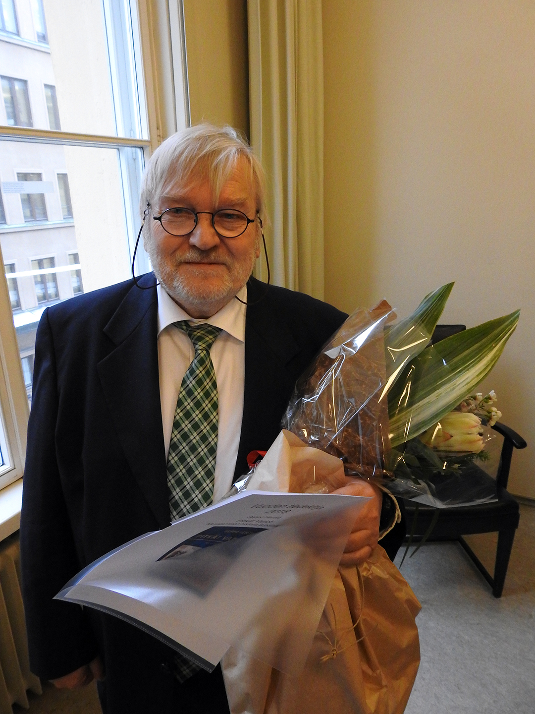 Voittaja Seppo Hentilä kukkien kanssa.