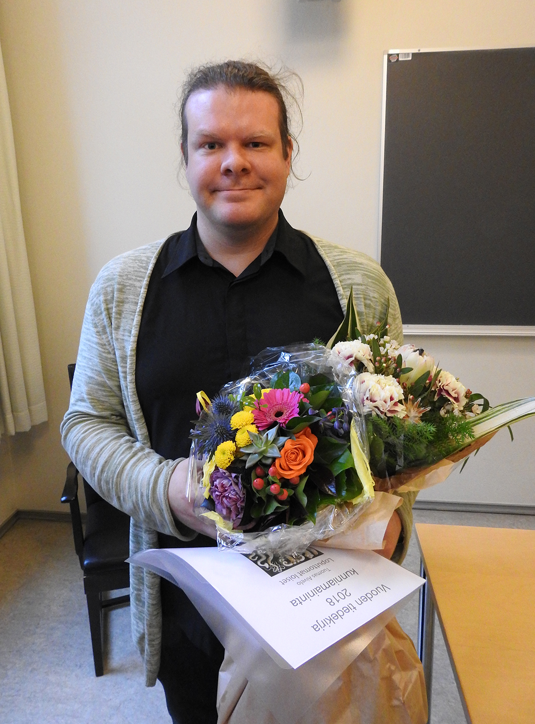 Tuomas Aivelo med blommor och diplom.