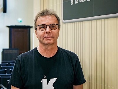 Mies, jolla silmälasit ja päällä musta paita.