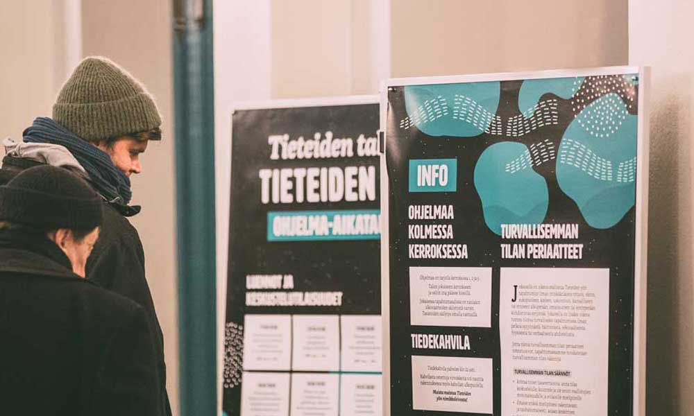 Två personer tittar på anslagstavlor med information om Vetenskapens natt.