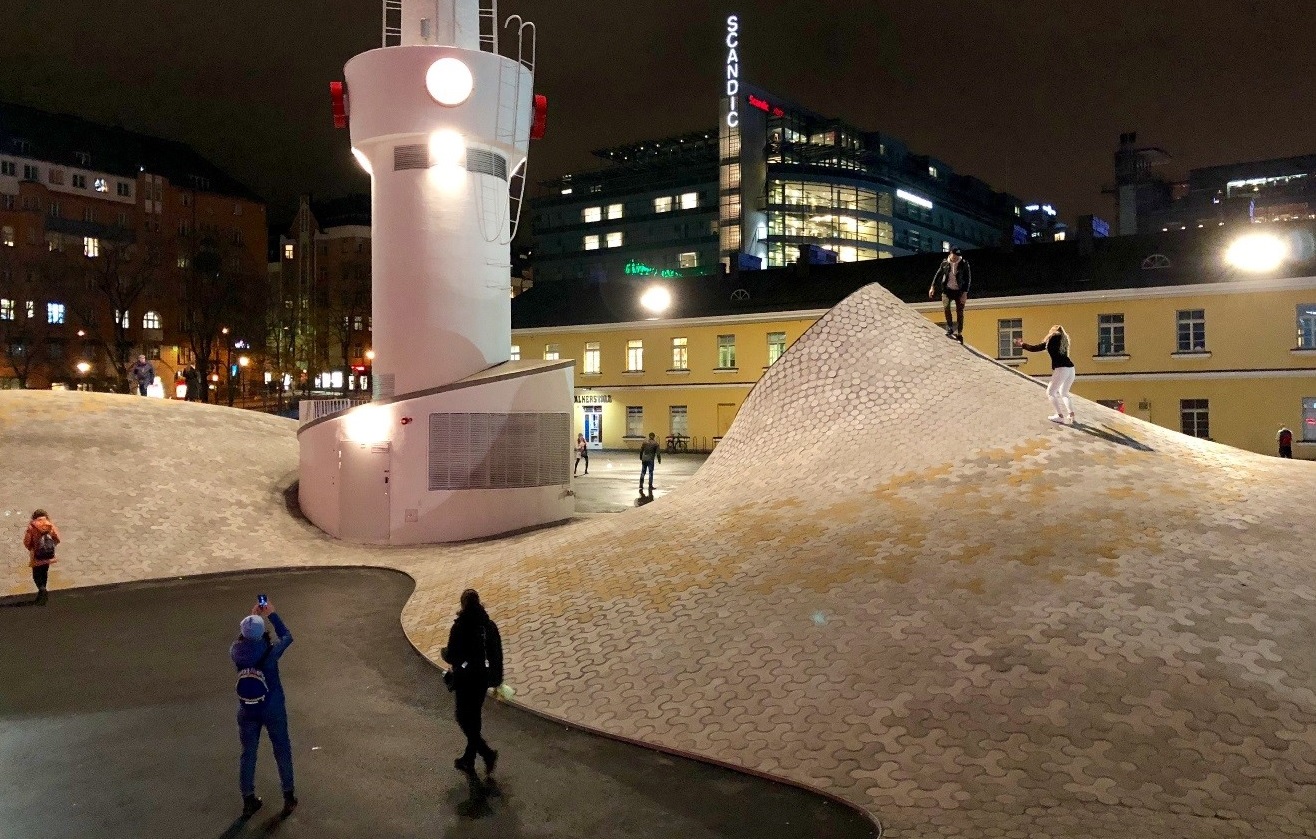 Människor vid Amos Rex konstmuseets takfönster på Glaspalatsets innergård.