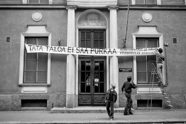 Rakennus, jonka edustalla roikkuu panderolli, jossa vedotaan rakennuksen säilyttämisen puolesta.