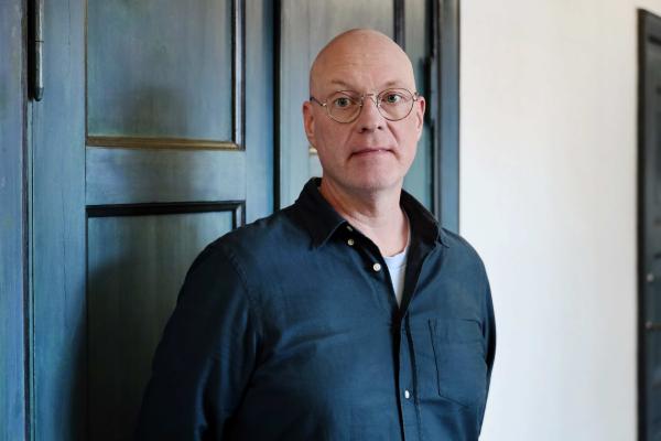 Janne Pölönen seisoo Tieteiden talolla sinisen oven edessä.