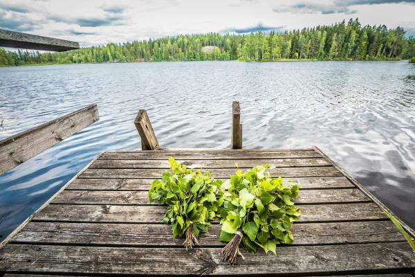 Kaksi koivusta tehtyä saunavihtaa puulaiturin päällä.