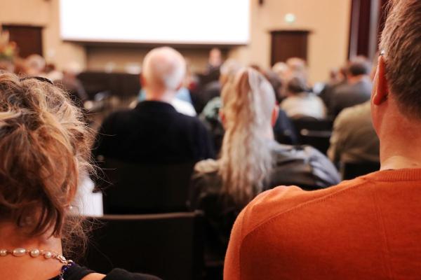 Salissa istuu ihmisiä, joita on kuvattu takaapäin.