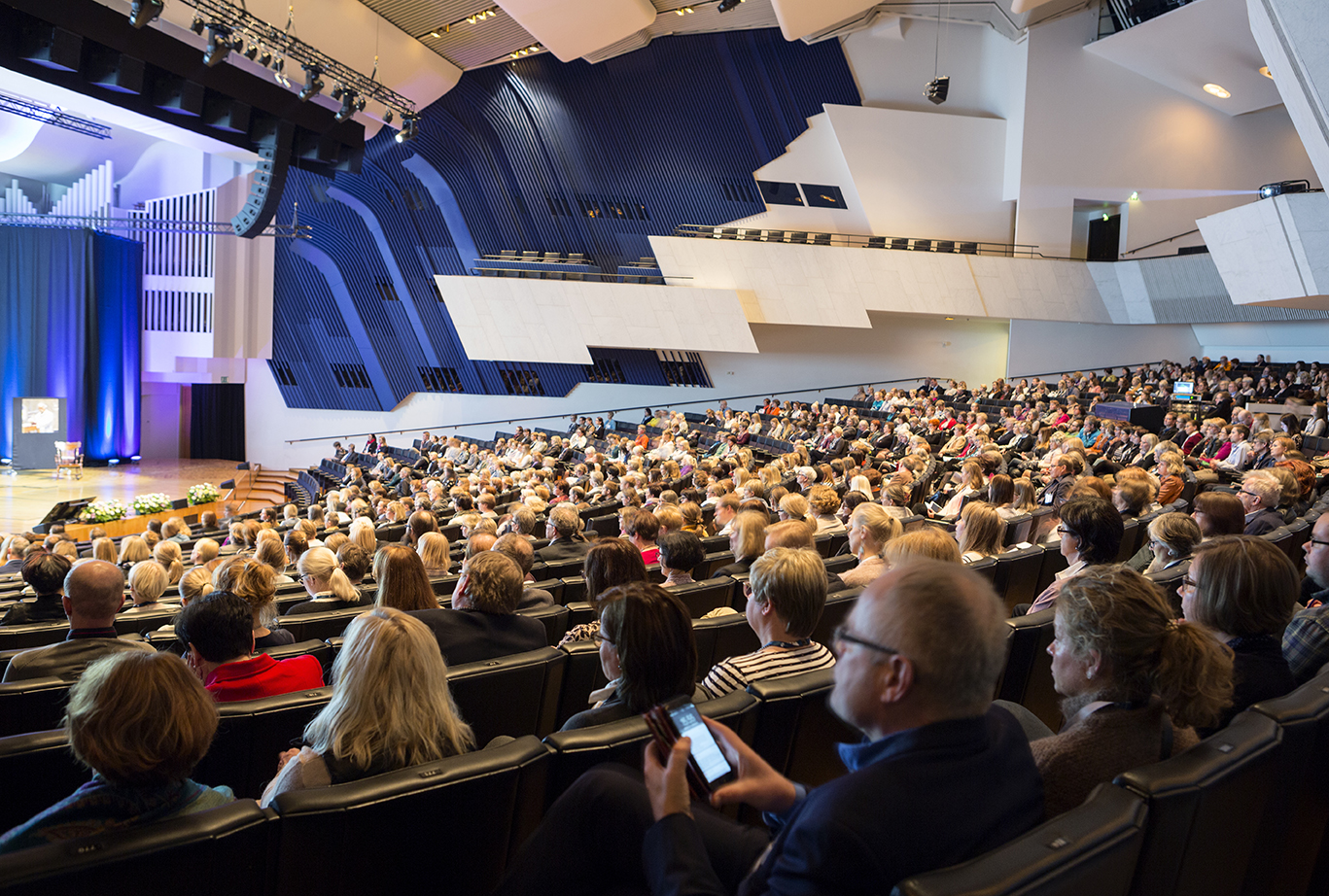 Ihmiset seuraavat Apollonian 125-vuotisjuhlasymposiumia Finlandia-talolla.