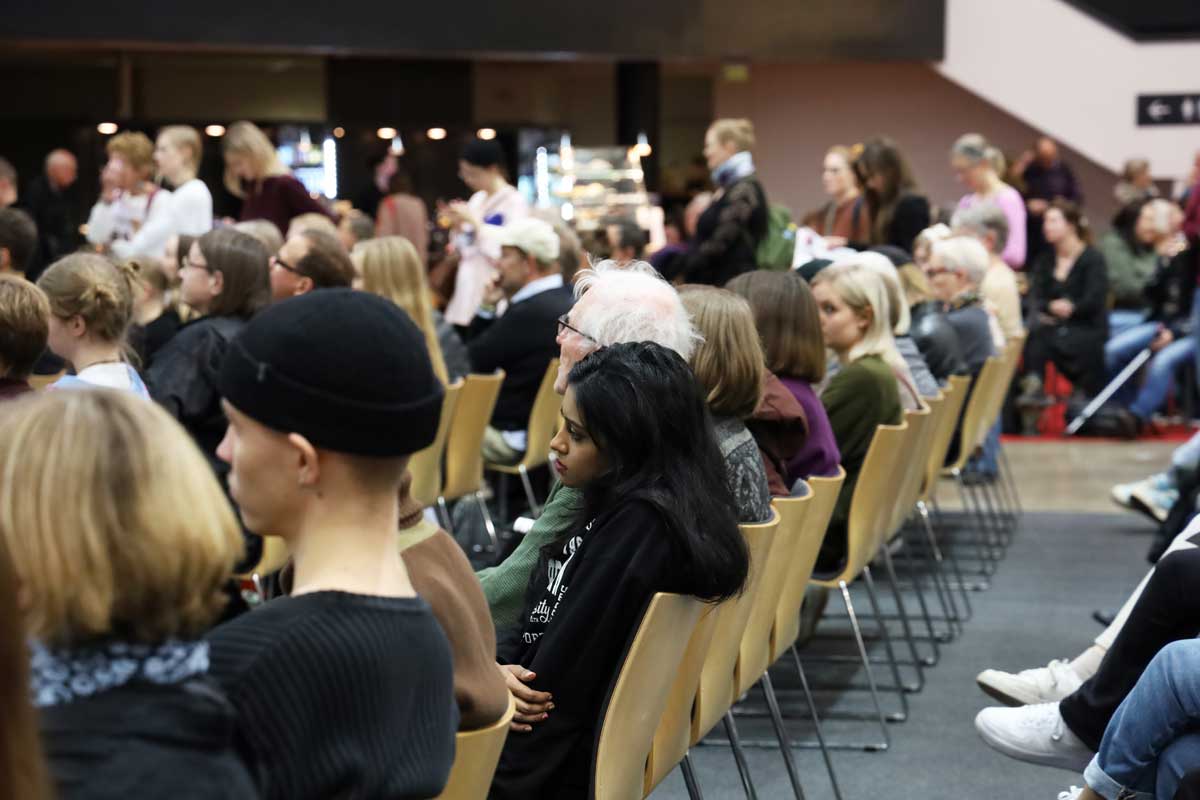 Runsaasti yleisöä istumassa tai seisomassa messulavan katsomossa.